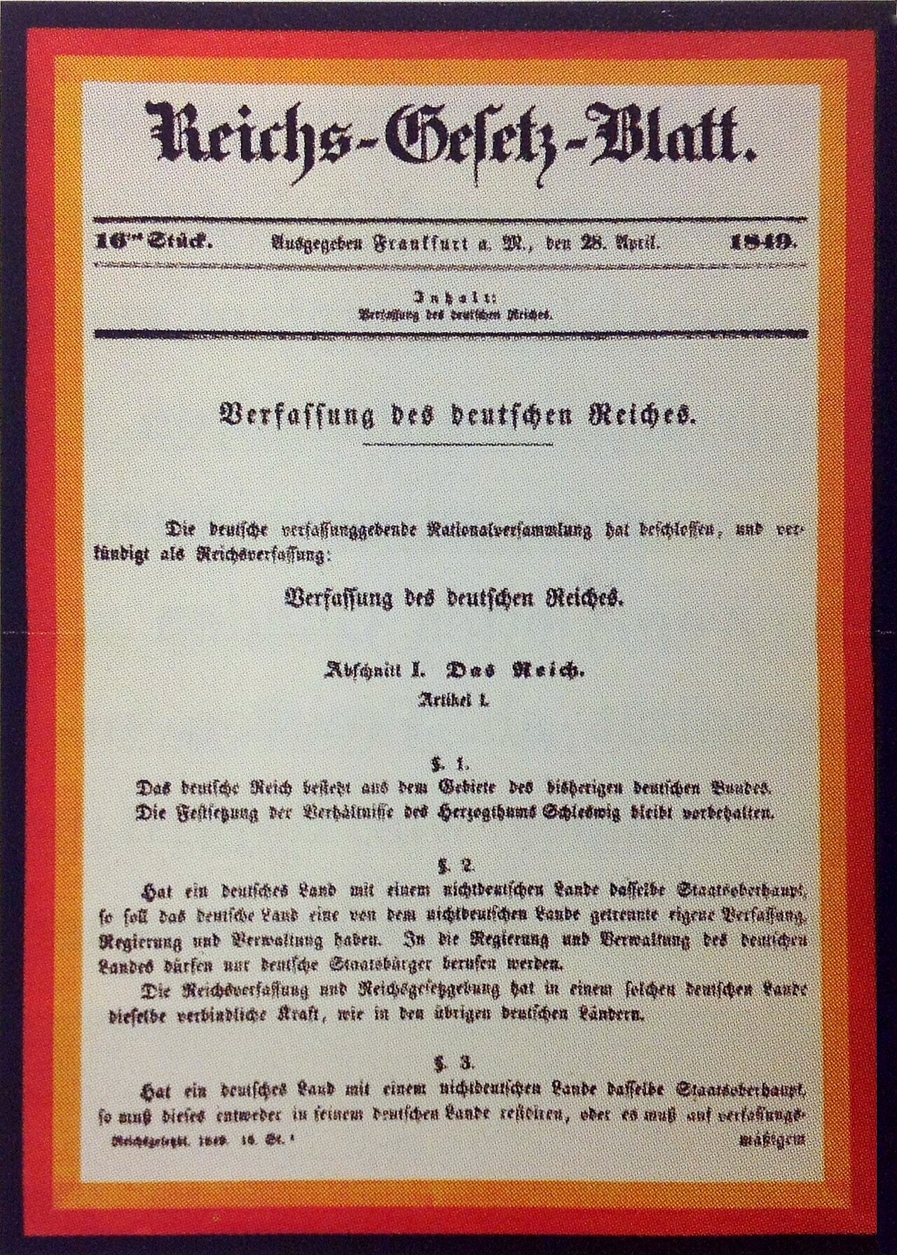 Farbfoto: Dokument mit schwarz-rot-goldenem Rand und altdeutschem Text.